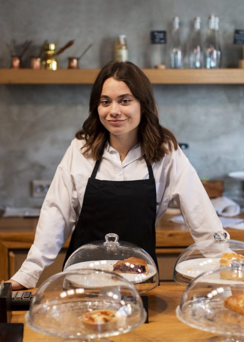 front-view-of-woman-in-apron-at-coffee-shop-scaled